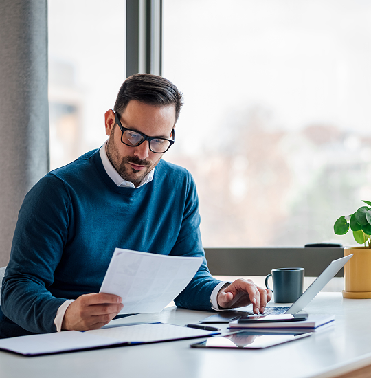 Businessman working at laptop and papers