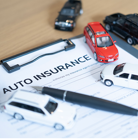 Auto insurance papers and toy vehicles